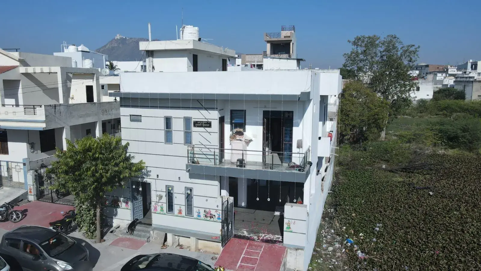 Aerial view of the completed G+1 house in an Udaipur residential colony with the Aravalli hills behind
