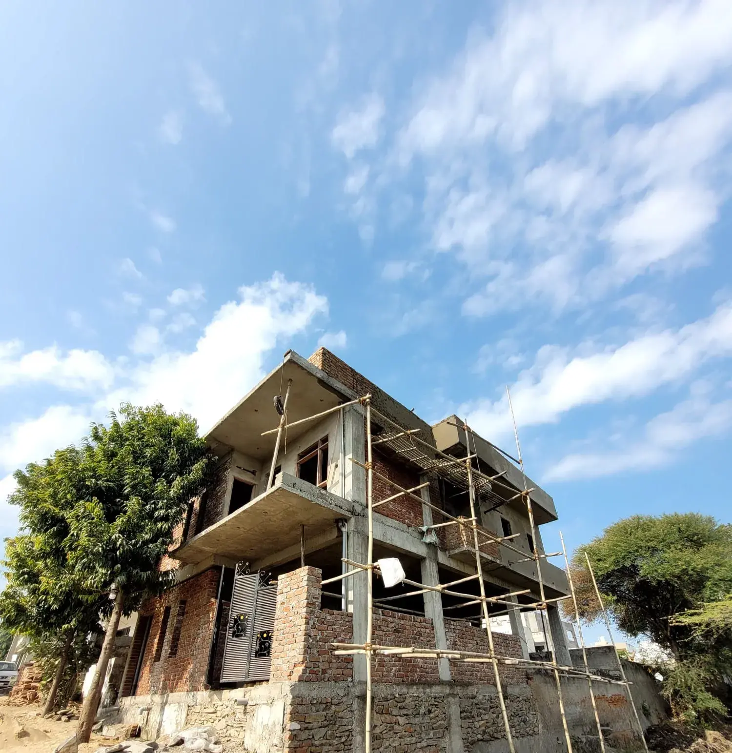 Construction stage: brick infill walls and balcony slab during house construction in Udaipur